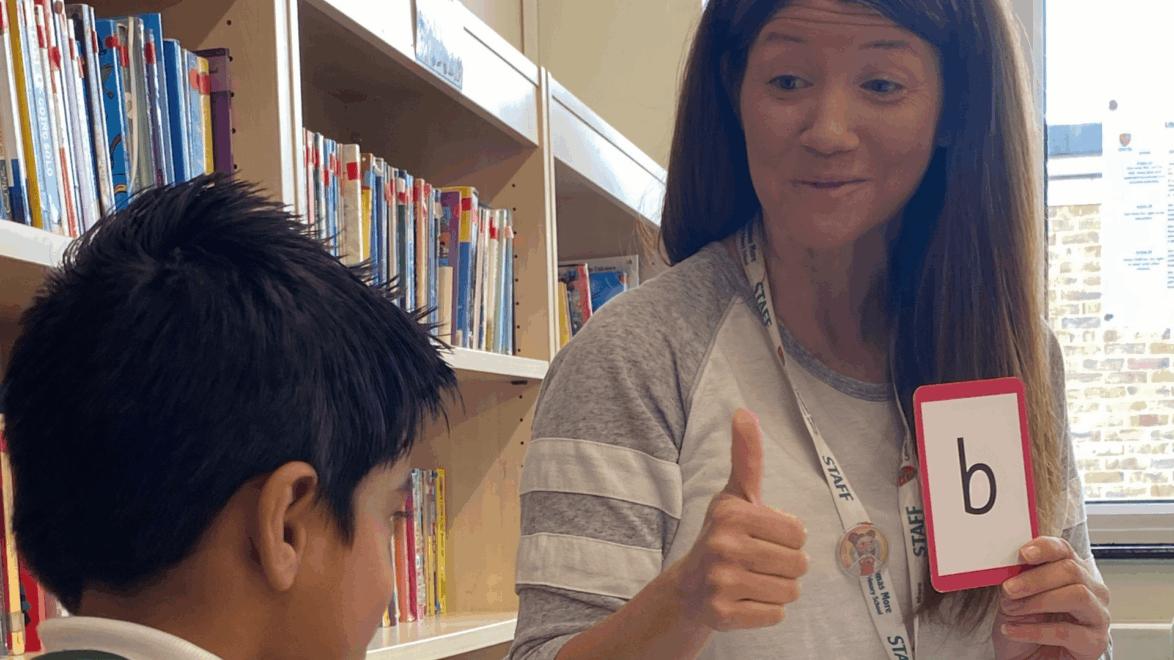 Teacher showing a flash card to a child